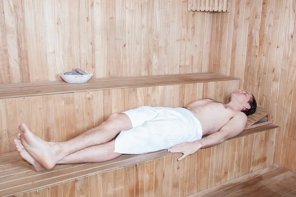 Mies makaa saunassa — kuvapankkivalokuva