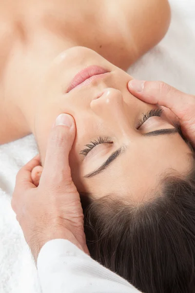 Man masseren van een vrouw op haar gezicht — Stockfoto