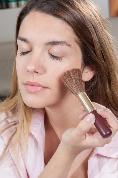 Mujer concentrada poniendo rubor — Foto de Stock