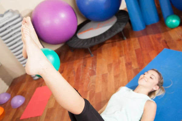 Mujer estirándose con una pelota — Foto de Stock