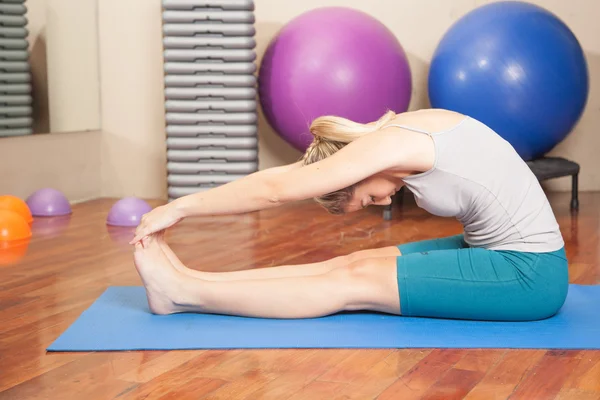 Mujer joven estirándose en yoga — Foto de Stock