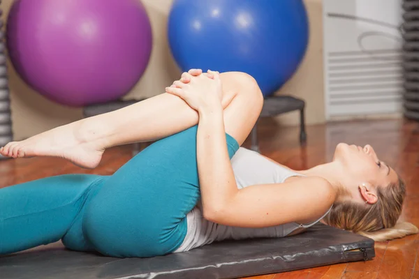 Mujer joven estirándose en yoga — Foto de Stock