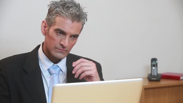 Overworked businessman sitting in office with laptop — Stock Video