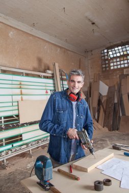 Masasında bir matkapla marangoz