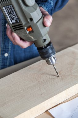 bir matkap tutan adam