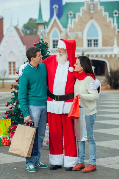 Weihnachtsmann mit einem jungen Paar — Stockfoto