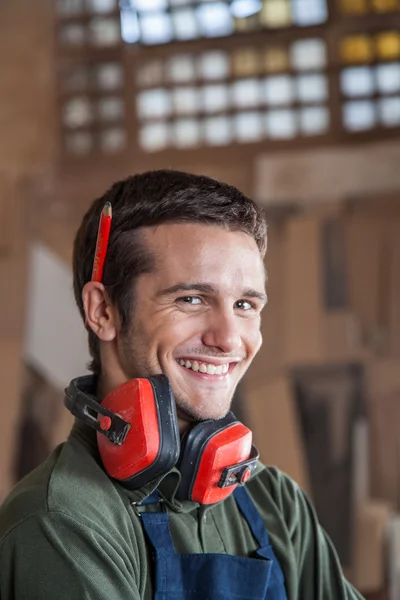 Carpintero sonriendo con protectores auditivos — Foto de Stock