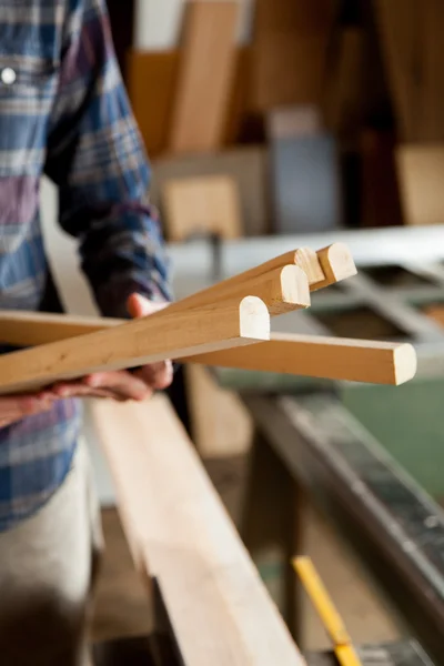 Carpintero sosteniendo trozos de madera — Foto de Stock