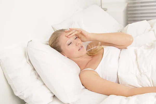 Jovem mulher acordando com dor de cabeça — Fotografia de Stock