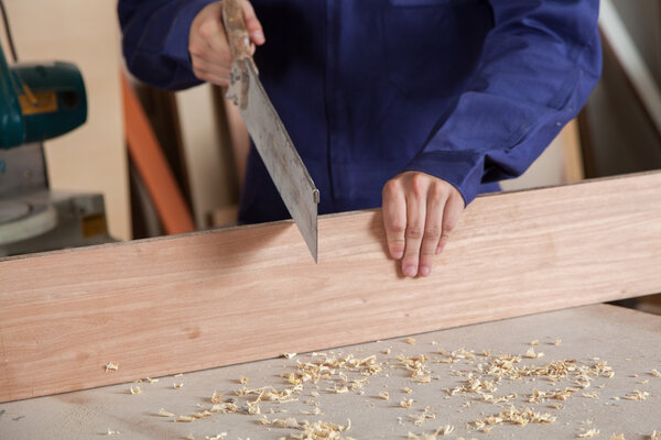 Carpenter cutting a piece of wood