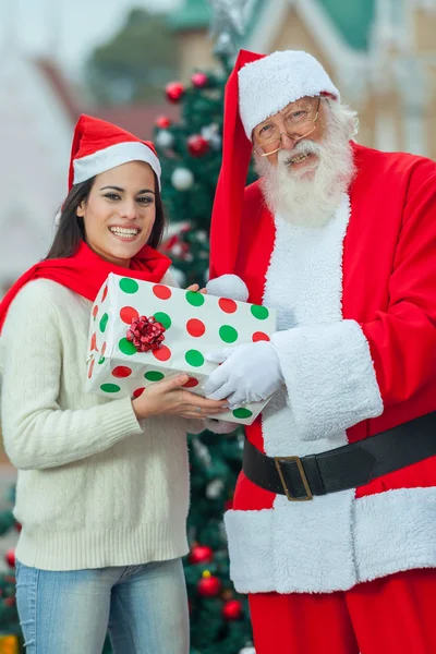 Санта дарит подарок молодой женщине — стоковое фото
