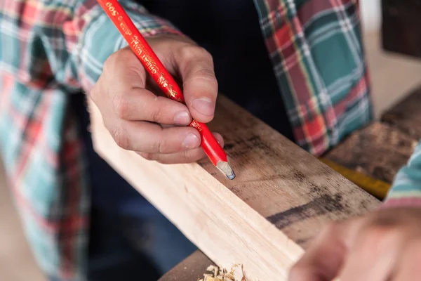 Carpintero marcando madera — Foto de Stock