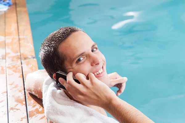 Hombre hablando en el teléfono móvil en la piscina — Foto de Stock