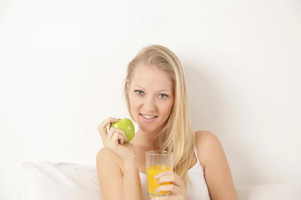 Mujer bebiendo jugo y comiendo una manzana —  Fotos de Stock