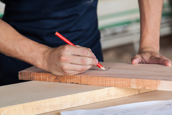 Carpenter marking a plank