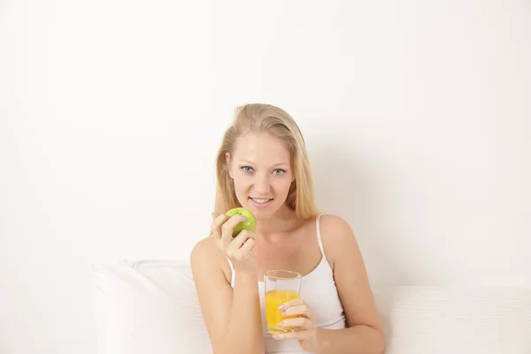 Frau trinkt Saft und isst einen Apfel — Stockfoto