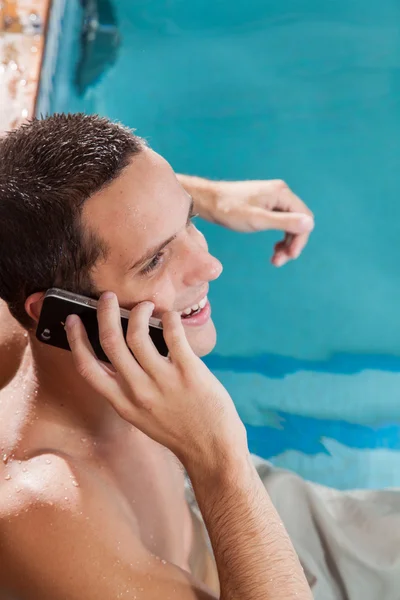 プールで携帯トウモロコシパンに話している男性 — ストック写真