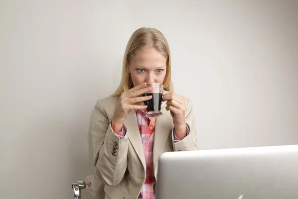 Mujer bebiendo cofee y trabajando con el ordenador —  Fotos de Stock