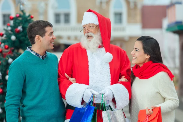 Weihnachtsmann mit einem jungen Paar — Stockfoto