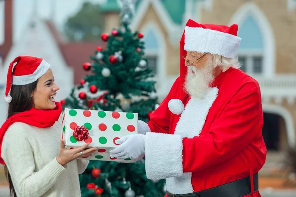 Der Weihnachtsmann schenkt einer jungen Frau — Stockfoto