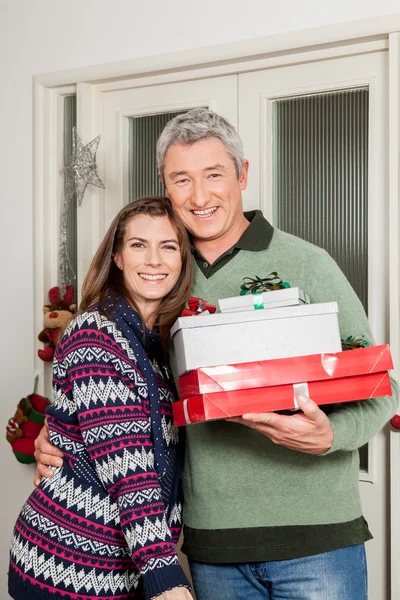 Vrouw knuffelen zijn echtgenoot en houden geschenk zakken — Stockfoto
