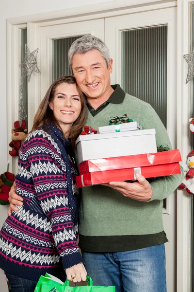 Happy couple holding a christmas gifts — Stock Photo, Image