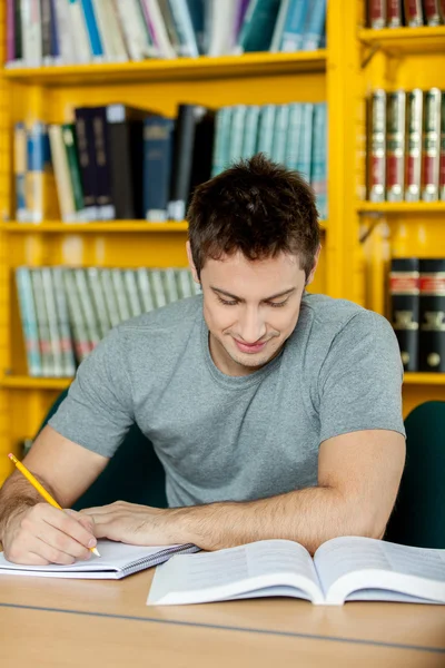 Hombre estudiando en la biblioteca — Foto de Stock