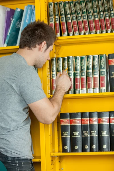 Homem à procura de um livro — Fotografia de Stock