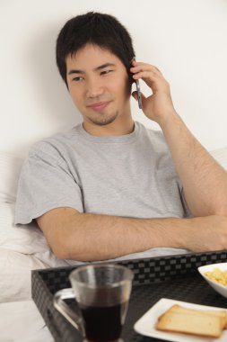 Kahvaltı yaparken telefonla konuşan adam