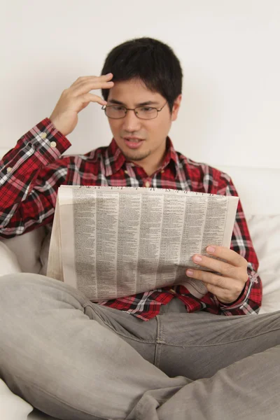 Hombre leyendo el periódico y preocupado por las noticias — Foto de Stock