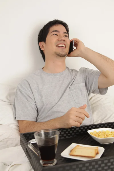 아침 식사 하는 동안 전화로 이야기 하는 남자 — 스톡 사진