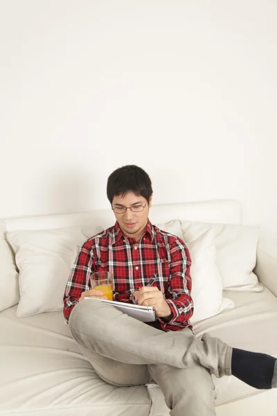 Hombre escribiendo y bebiendo un jugo — Foto de Stock