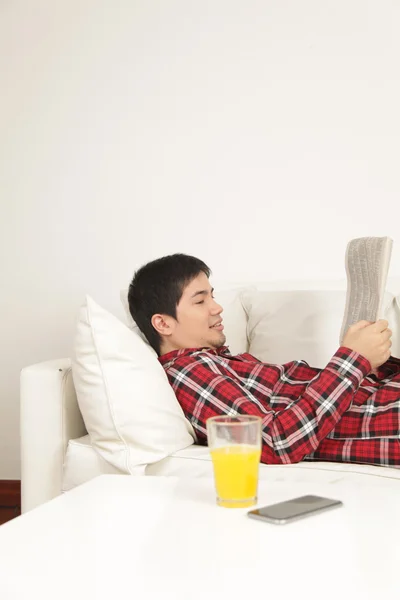 Человек, читающий газету и пьющий сок — стоковое фото