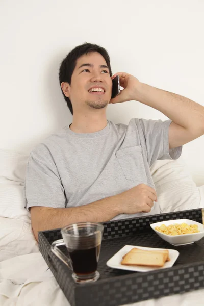 아침 식사 하는 동안 전화로 이야기 하는 남자 — 스톡 사진