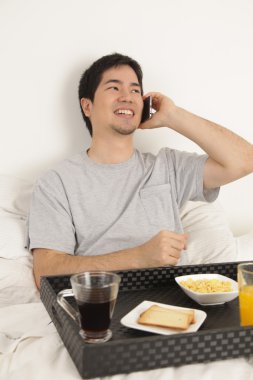 Kahvaltı yaparken telefonla konuşan adam
