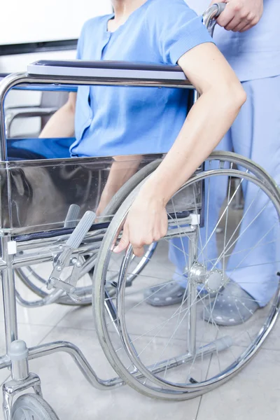 Enfermeira ajudando uma mulher em cadeira de rodas — Fotografia de Stock