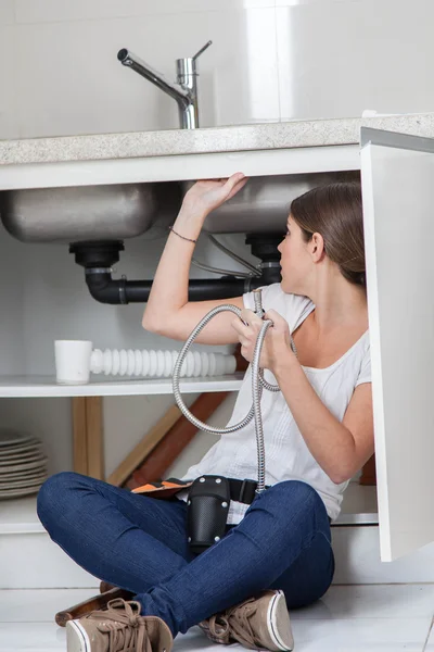 Plumber woman fixing the pipe — Stock Photo, Image