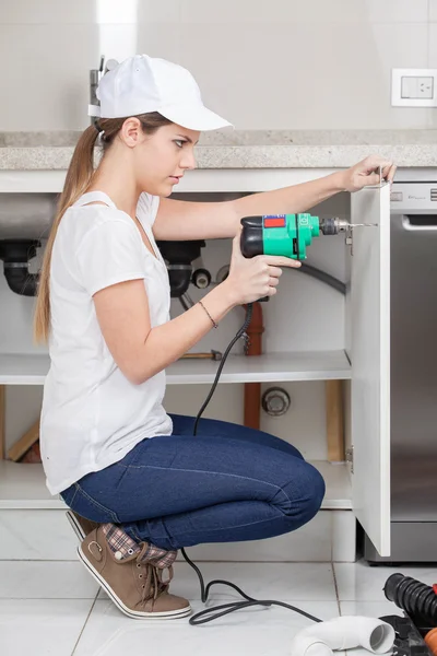 Vrouw loodgieter werken met boor — Stockfoto