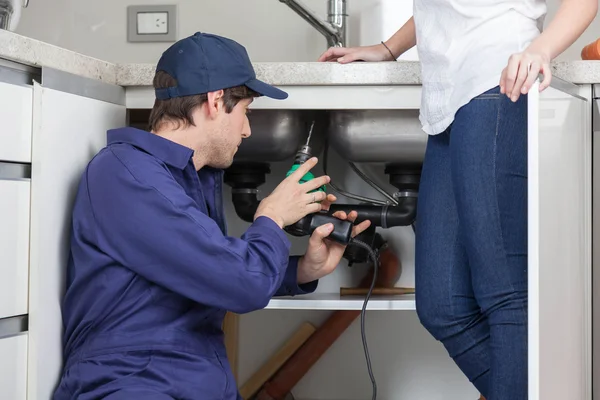 Plumber fixing a sink — Stock Photo, Image