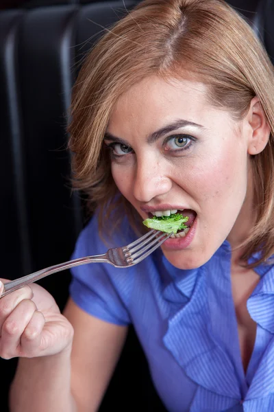 Vrouw eten broccoli — Stockfoto