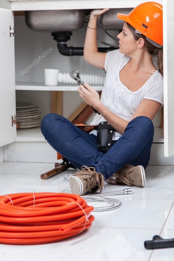 female plumber fixing the pipe