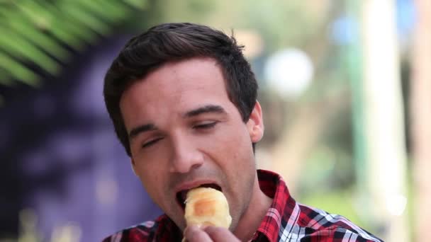 Hombre comiendo una medialuna — Vídeos de Stock