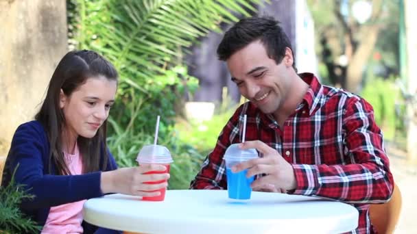 Man with a girl drinking a milkshake — Stock Video