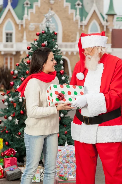 Weihnachtsmann schenkt einer jungen Frau eine Geschenkbox — Stockfoto
