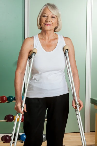 Woman with a neck brace using crutches — Stock Photo, Image