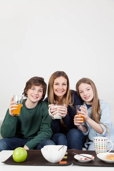 Mom with son and daughter drinking juice — Stock Photo, Image