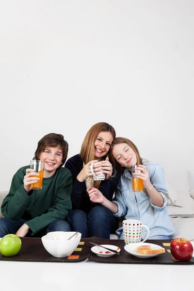 Mom with son and daughter drinking juice — Stock Photo, Image