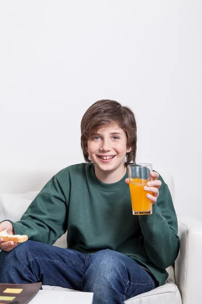 Хлопчик тримає сік і тост — стокове фото
