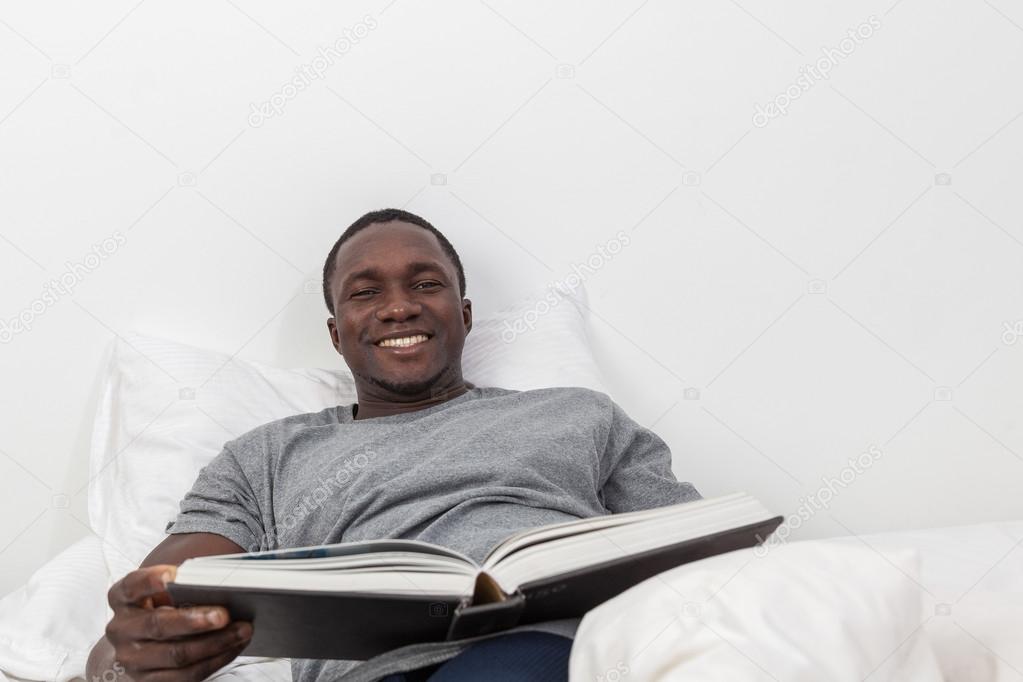 Black man reading a book — Stock Photo © Implementar 88680996