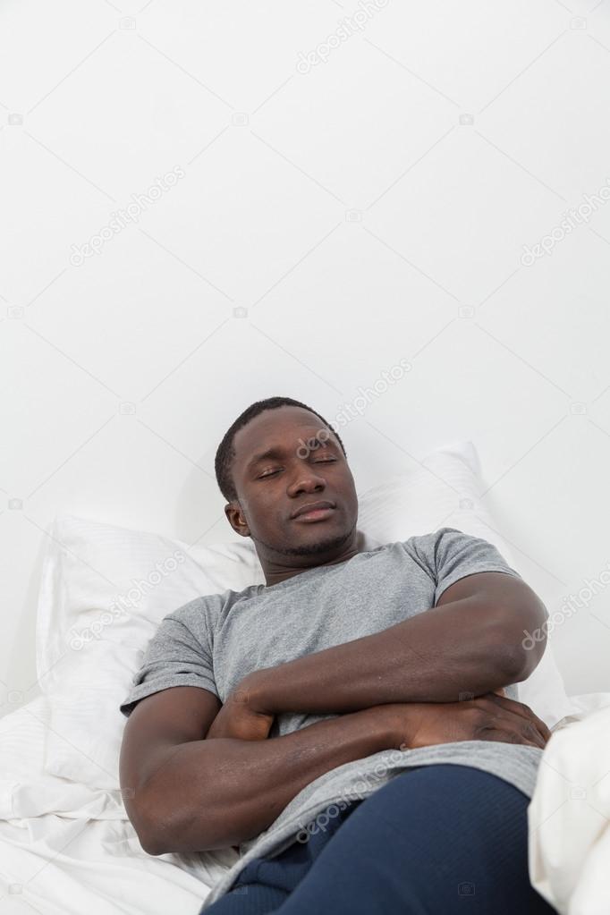 Black man sleeping in bed